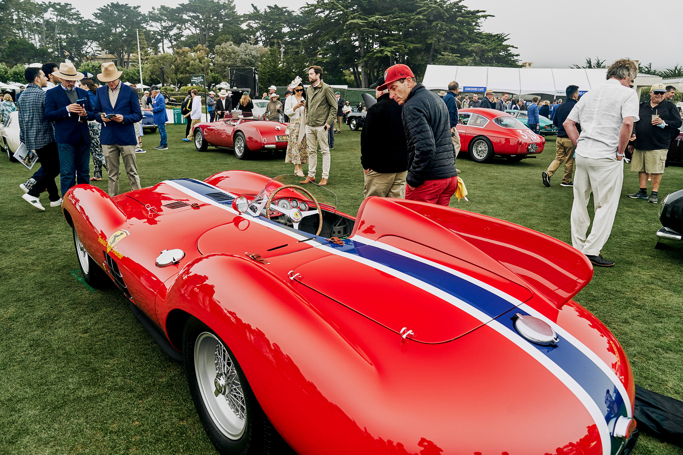 Attendees admiring a car.