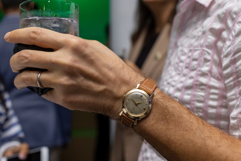 Hamilton pictured on wrist while holding a cocktail. 