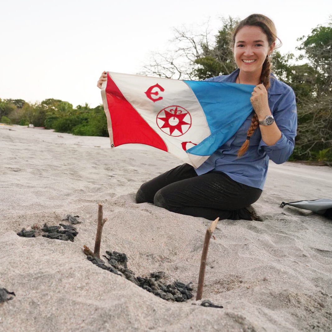 Callie Veelenturf holding the Explorers Club flag