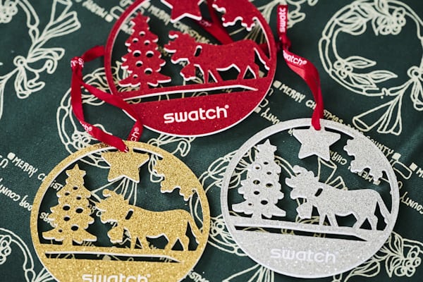 The ornaments with the The Swatch Golden Merry Christmas sweater watch.