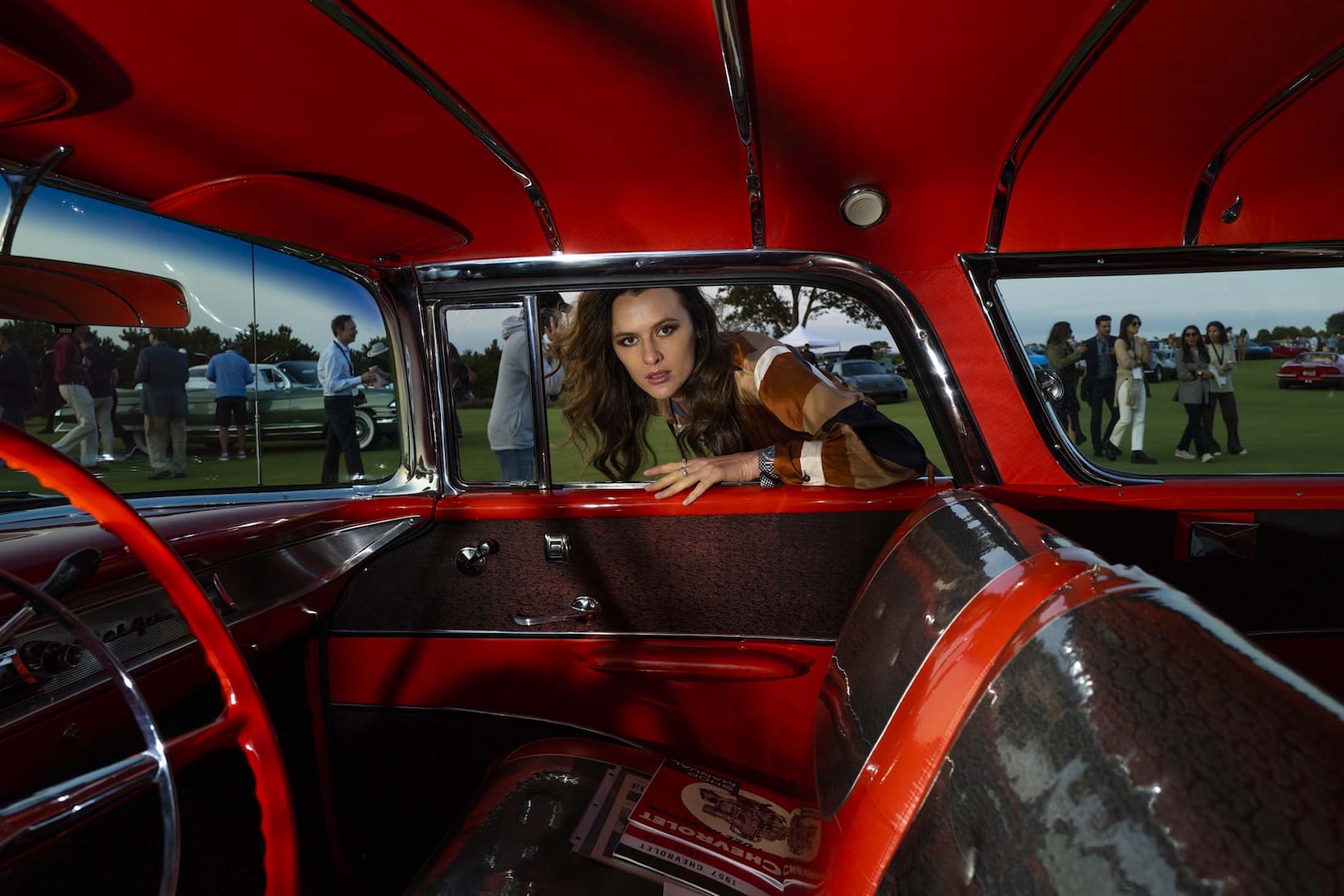 Woman leaning into A racecar.