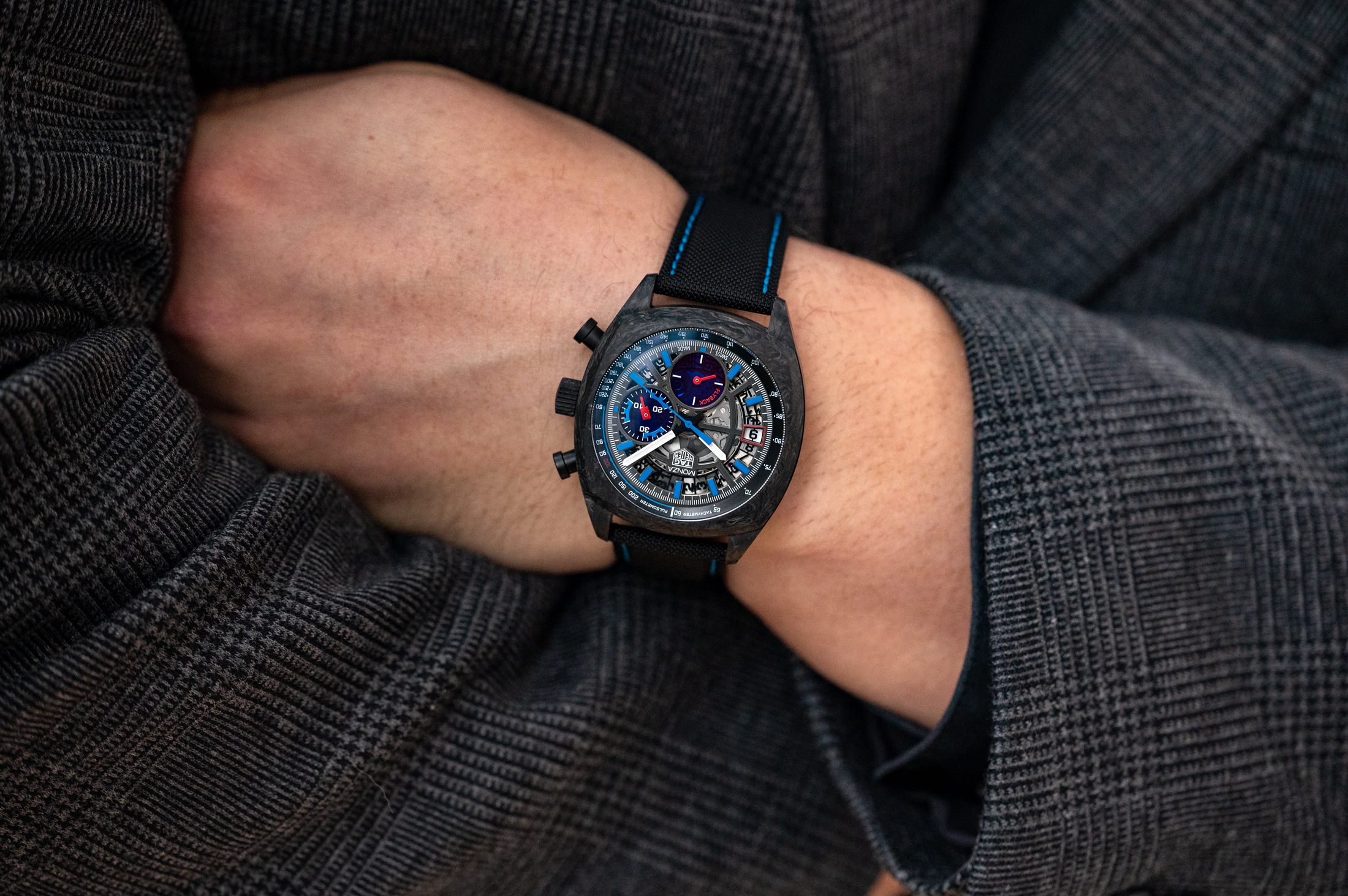 The TAG Heuer Monza watch on the wrist of a man wearing a checked suit
