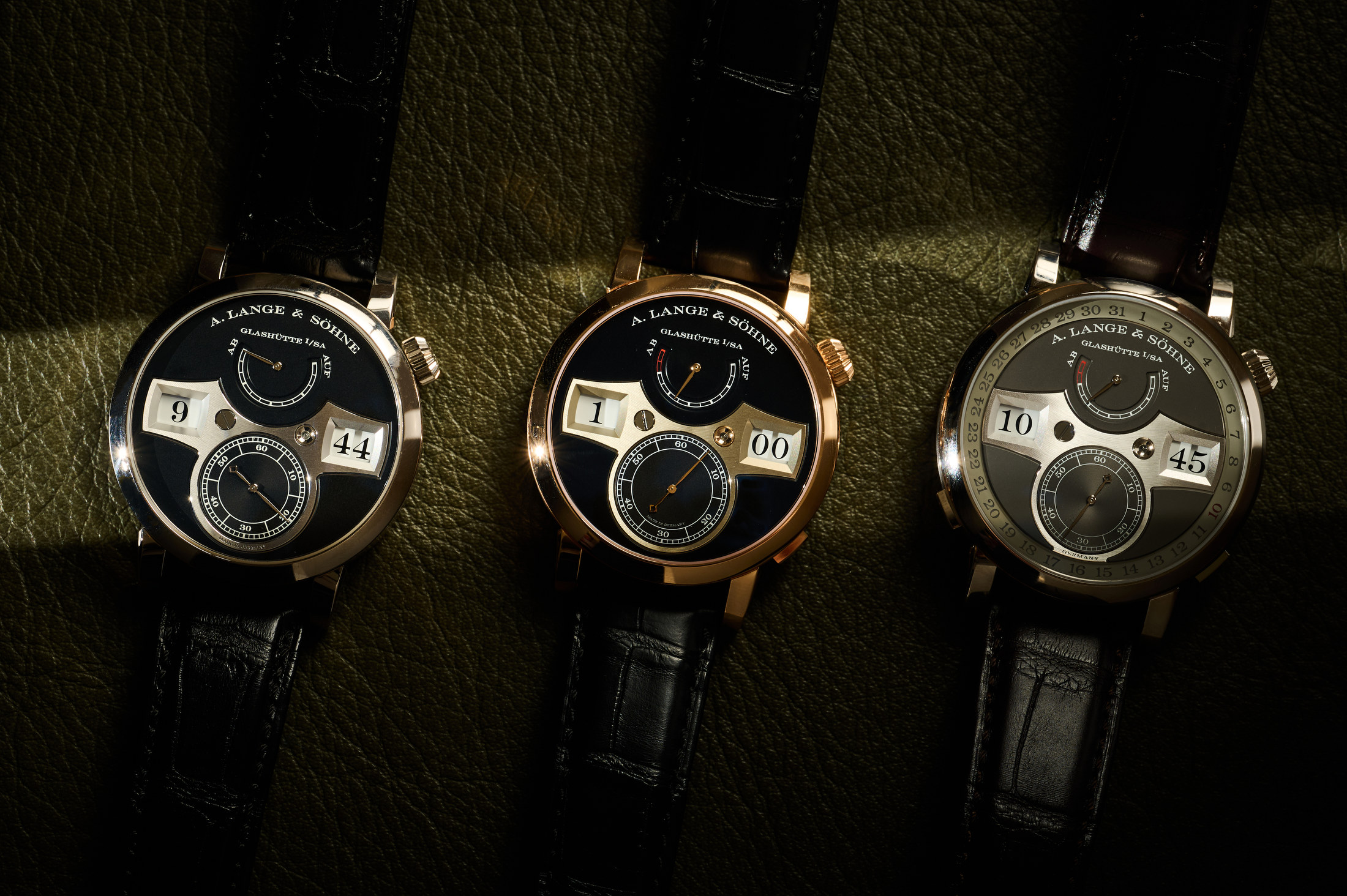 Three different Lange Zeitwerk watches laying on a table