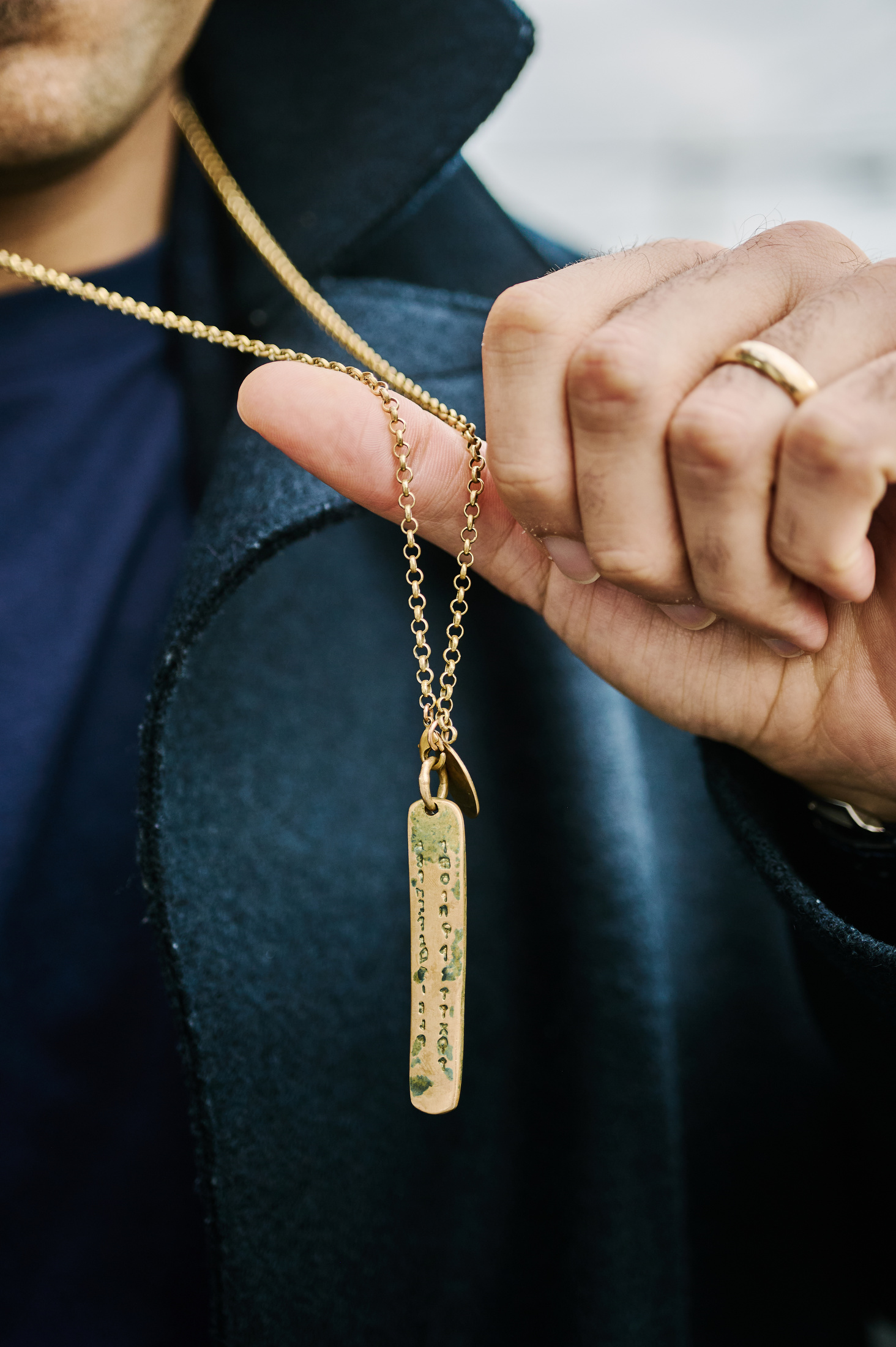 A necklace held up by the hand.