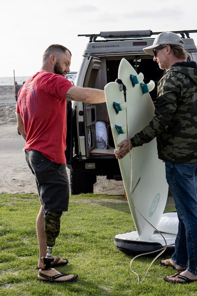 A veteran looking at a surfboard.