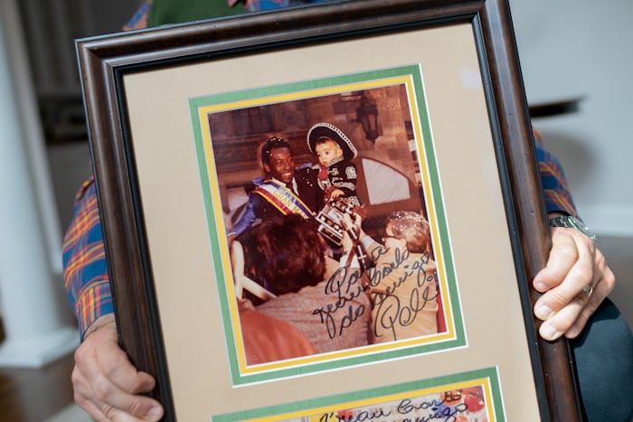 a framed photo of a child and pele 