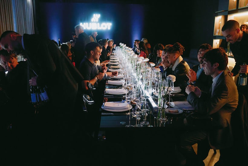 people sitting at a hublot-themed dinner