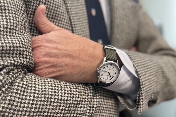 A person wearing a Timex Easy Reader and houndstooth blazer