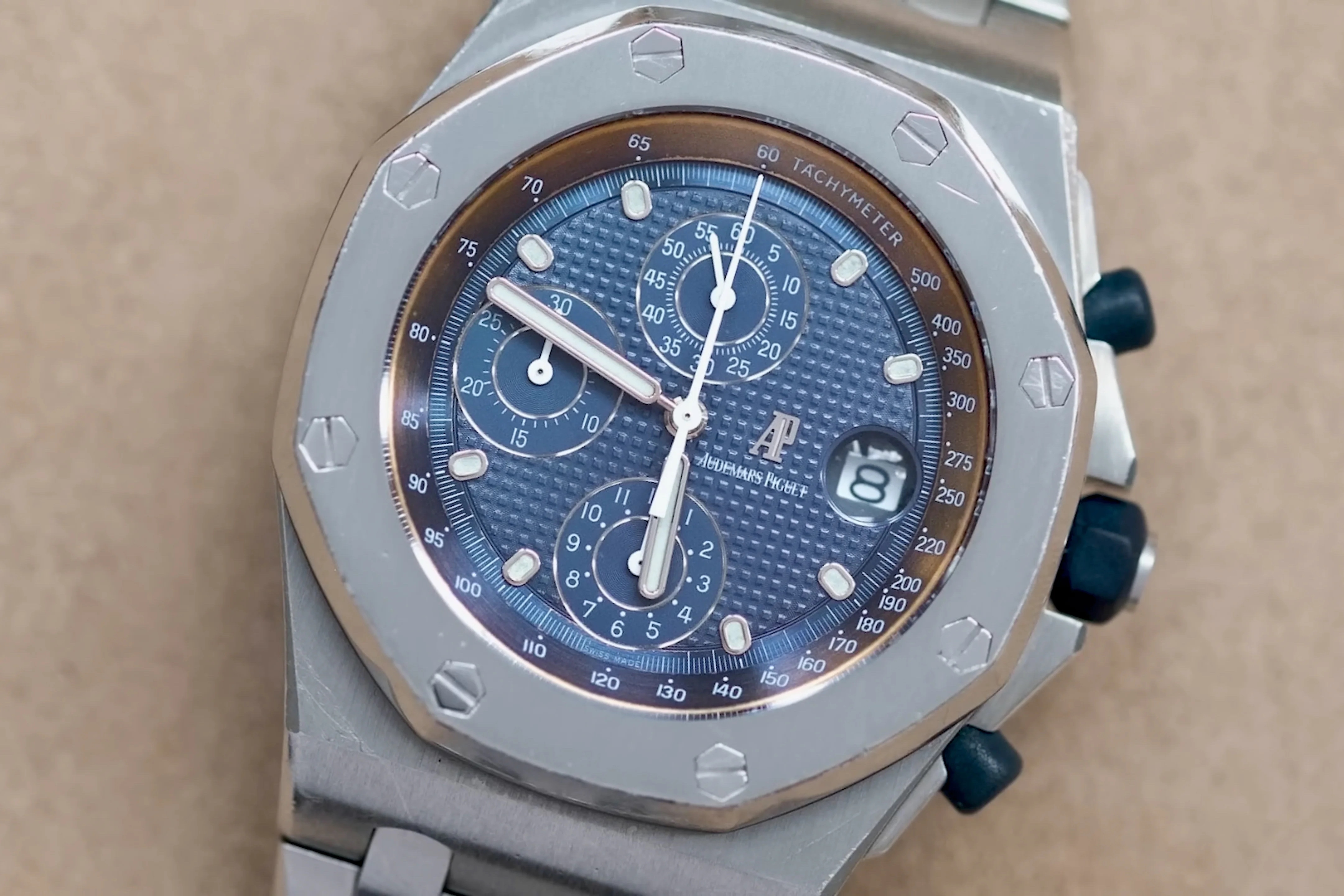 watch with blue dial facing up from flat surface