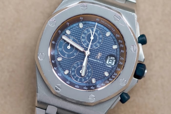 watch with blue dial facing up from flat surface