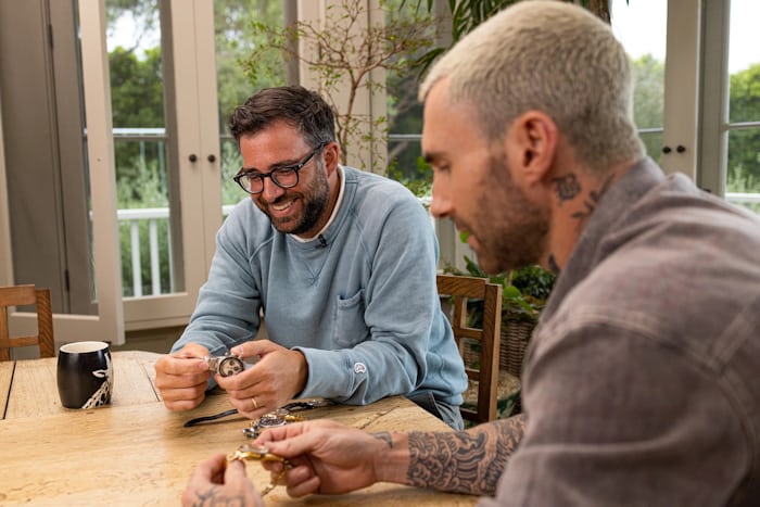 Ben Clymer smiles while he and Adam Levine talk watches