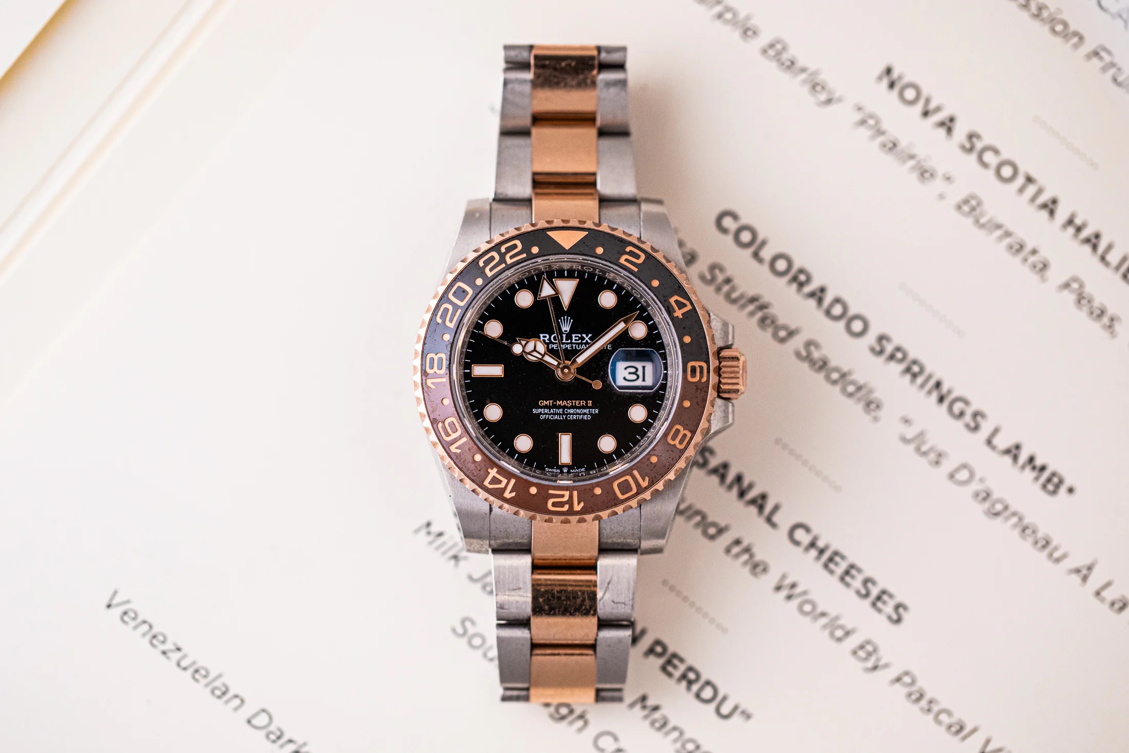 Rolex GMT-Master II root beer placed on top of a dinner menu