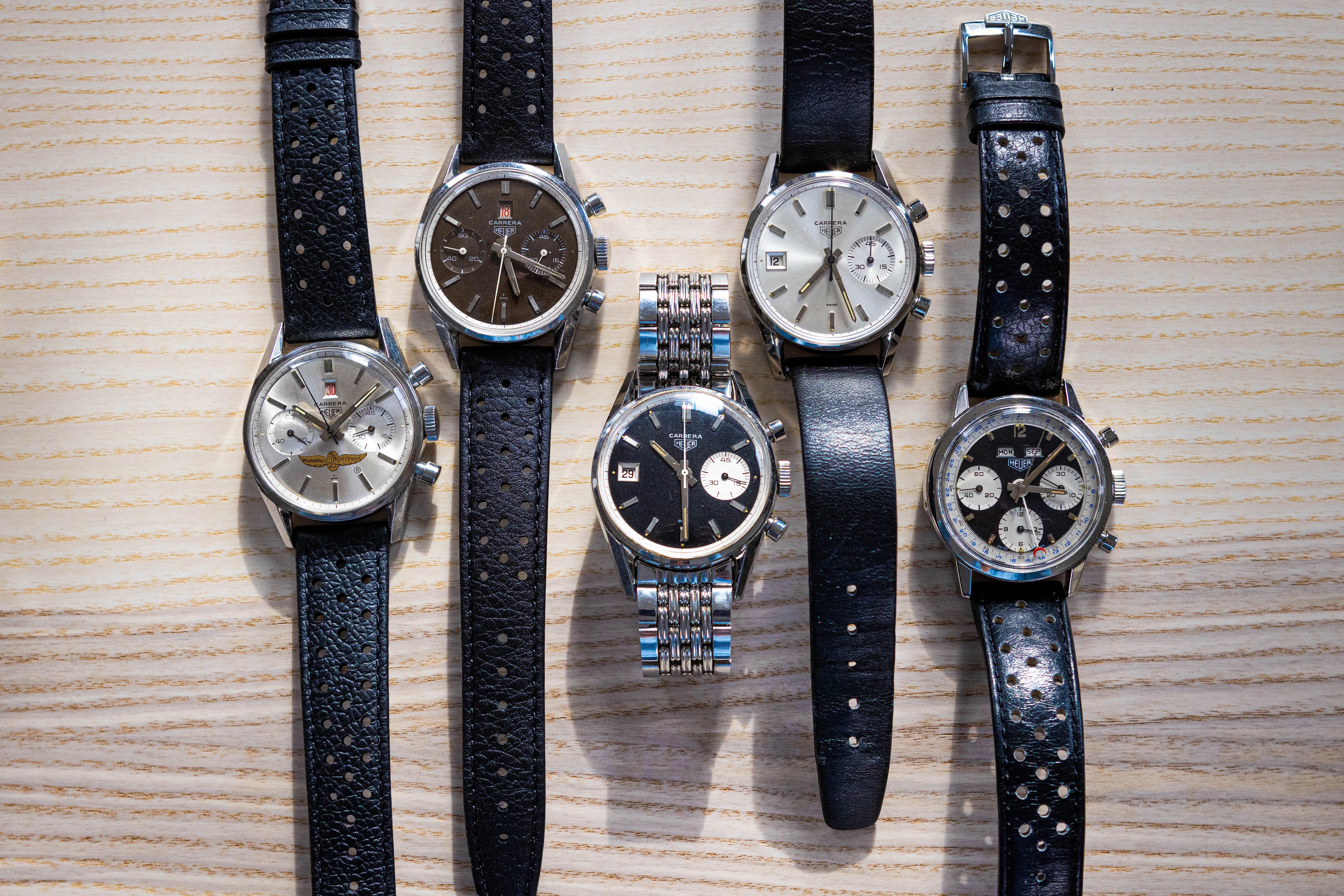 A group of Dato Carrera watches laid out on a wooden surface