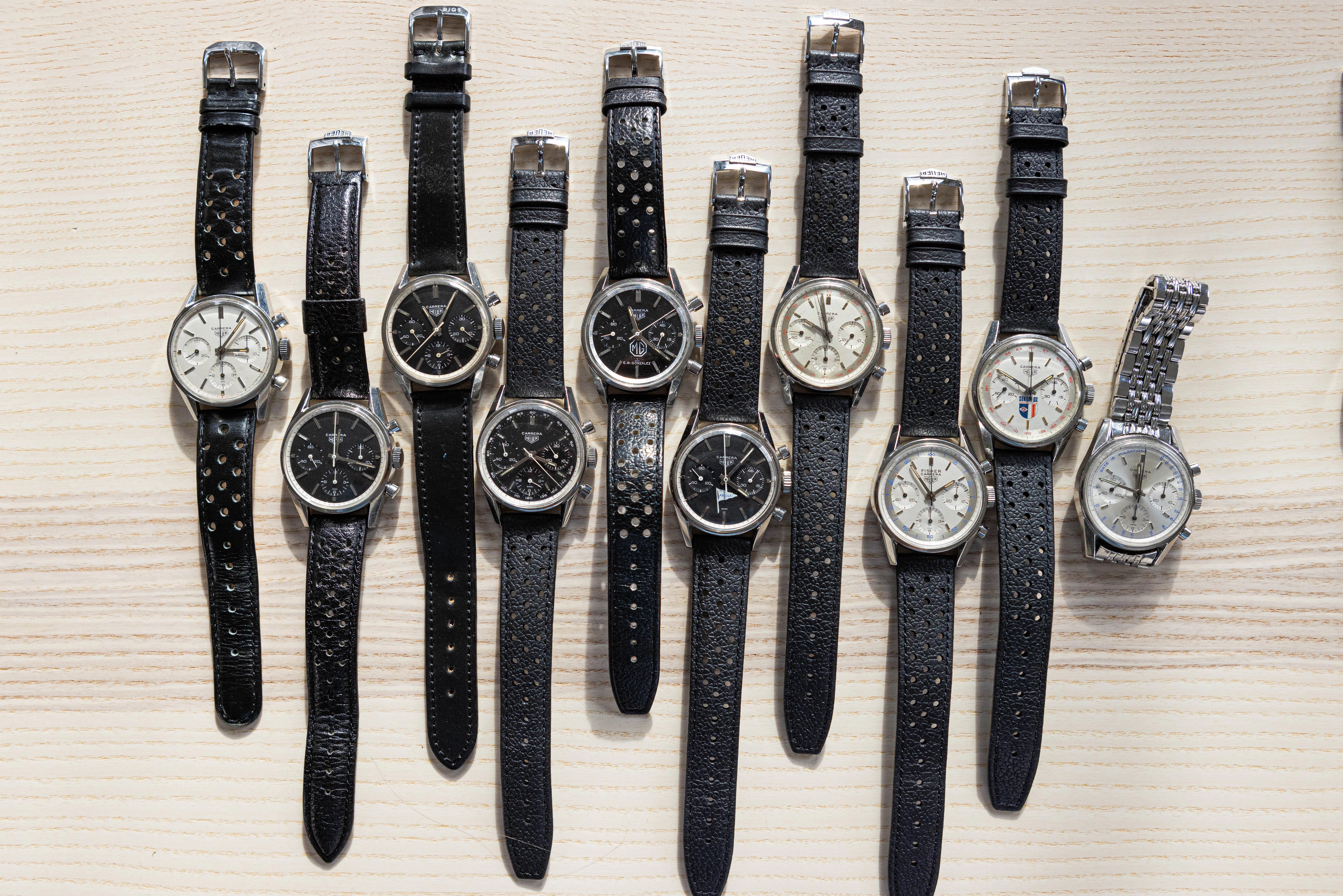 A collection of Carrera watches laid out on a wooden surface