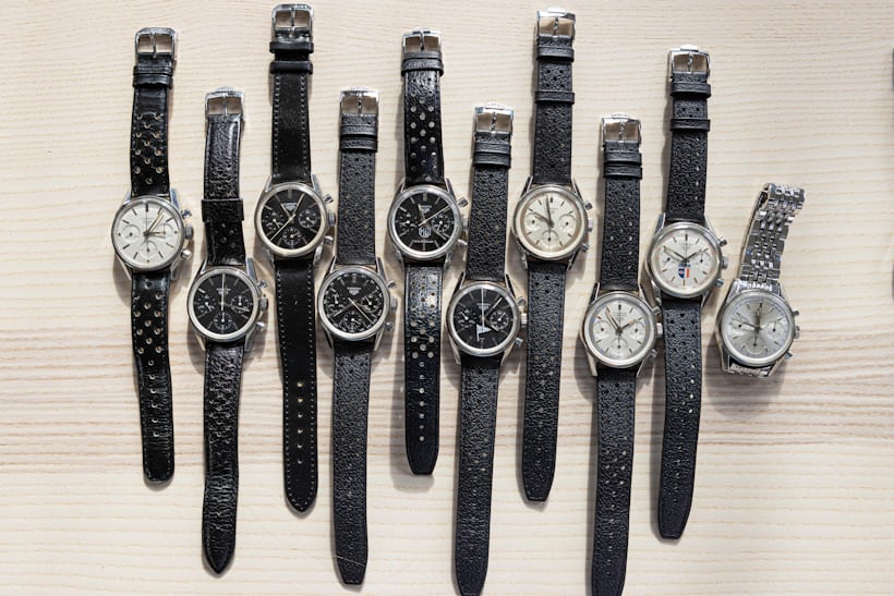 A collection of Carrera watches laid out on a wooden surface