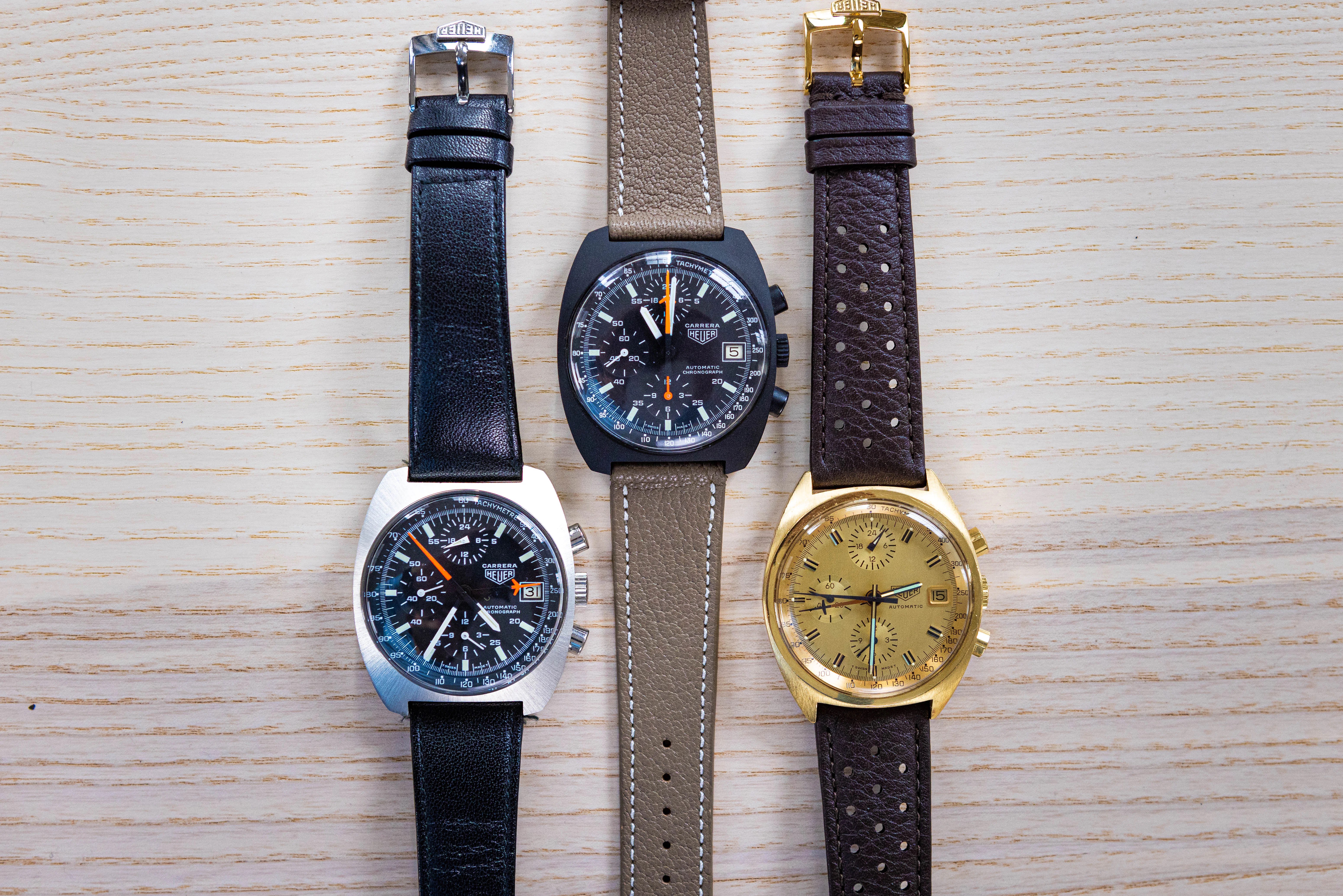 Three carrera watches laid out on a wooden surface