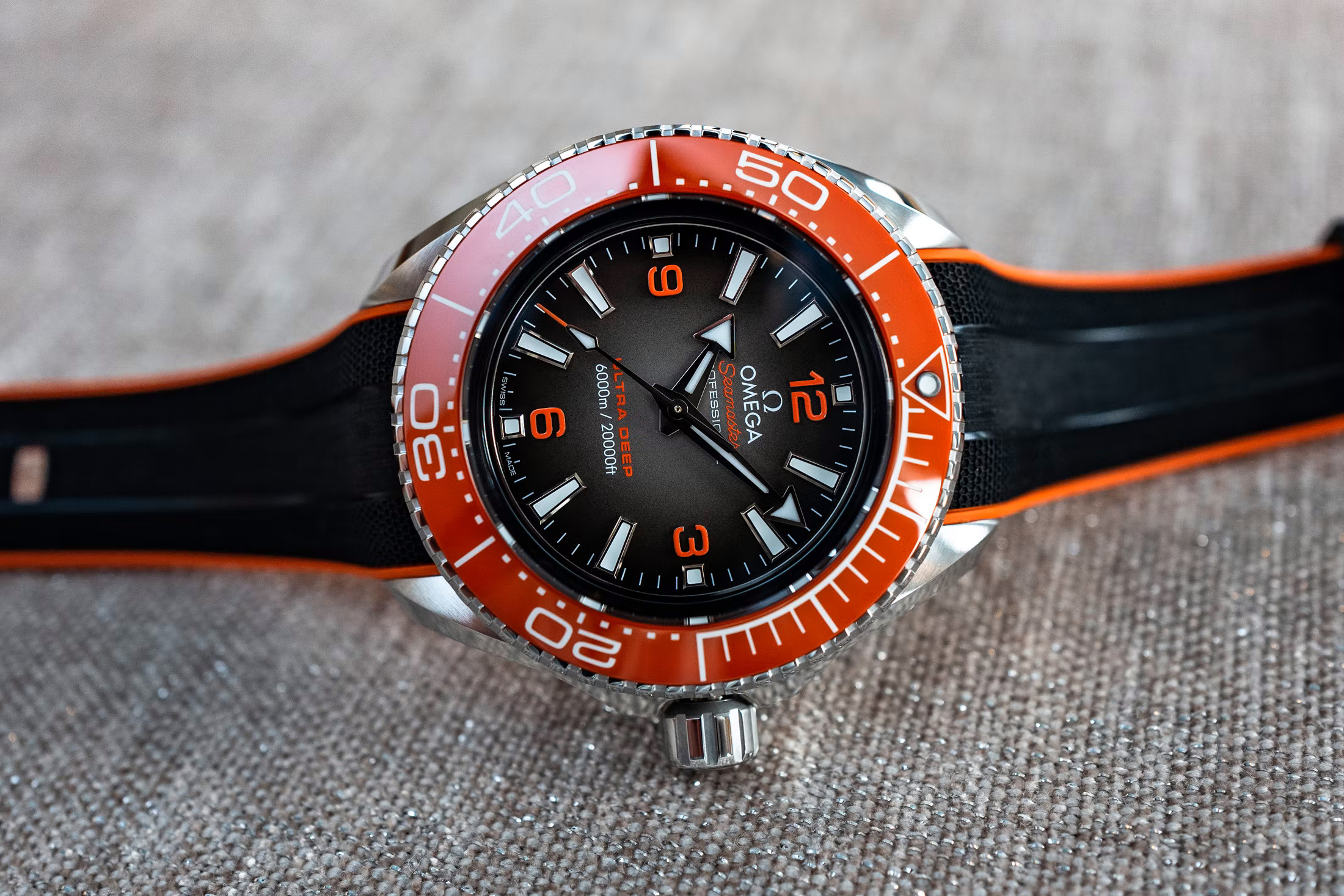 the black dial ultra deep on a rubber strap on a table. 