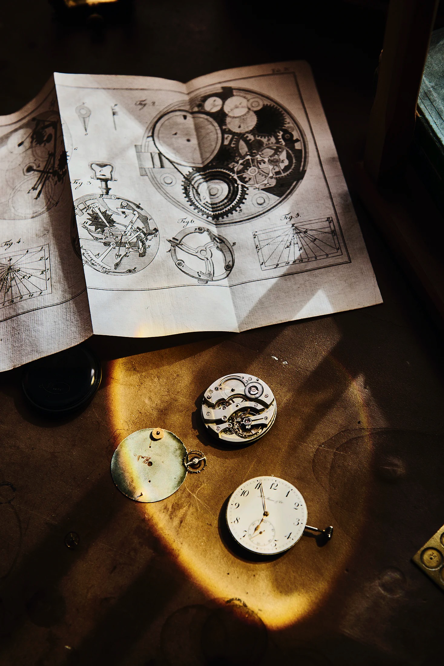 Pocket watch movements and papers on a work bench 