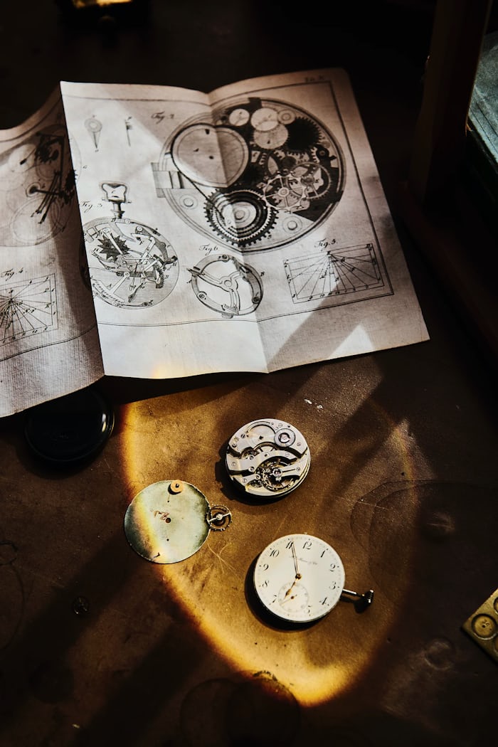 Pocket watch movements and papers on a work bench 