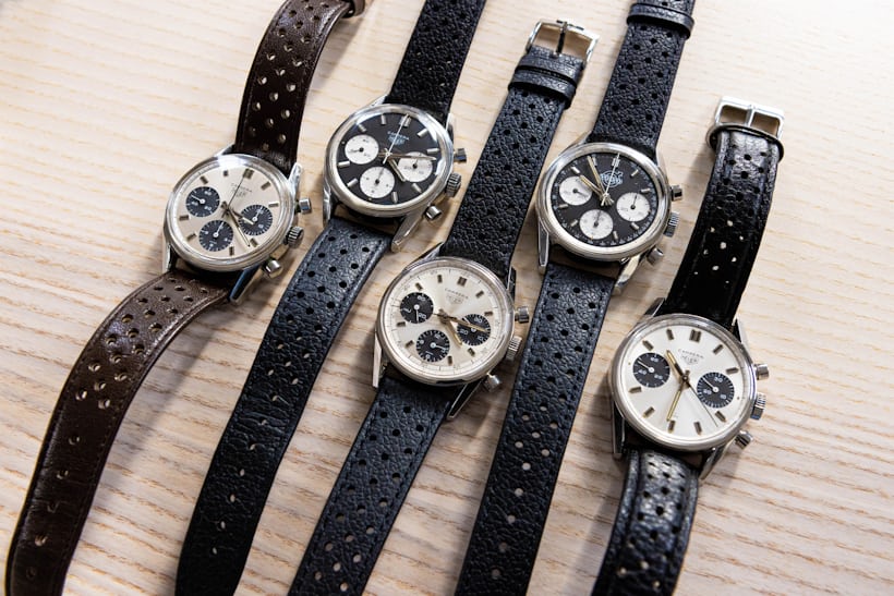 A group of Carrera watches with Panda and Reverse Panda dials laid out on a wooden surface