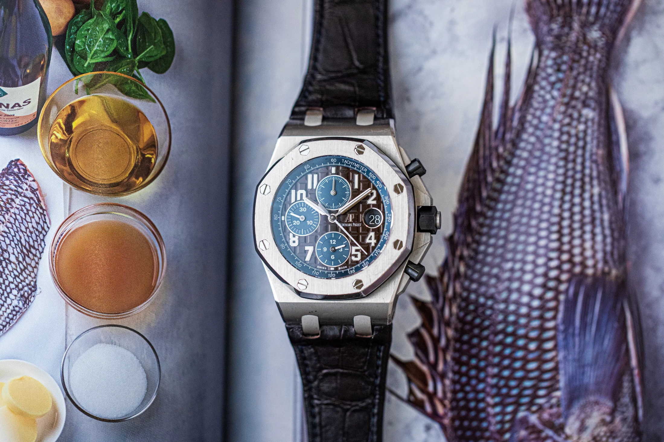 Audemars Piguet Royal Oak Offshore on top of a book featuring photos of food