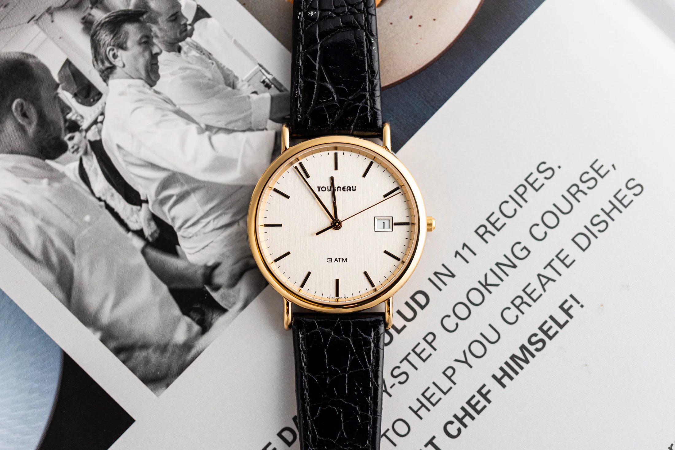 Torneau watch positioned on top of a page from Daniel Boulud's book