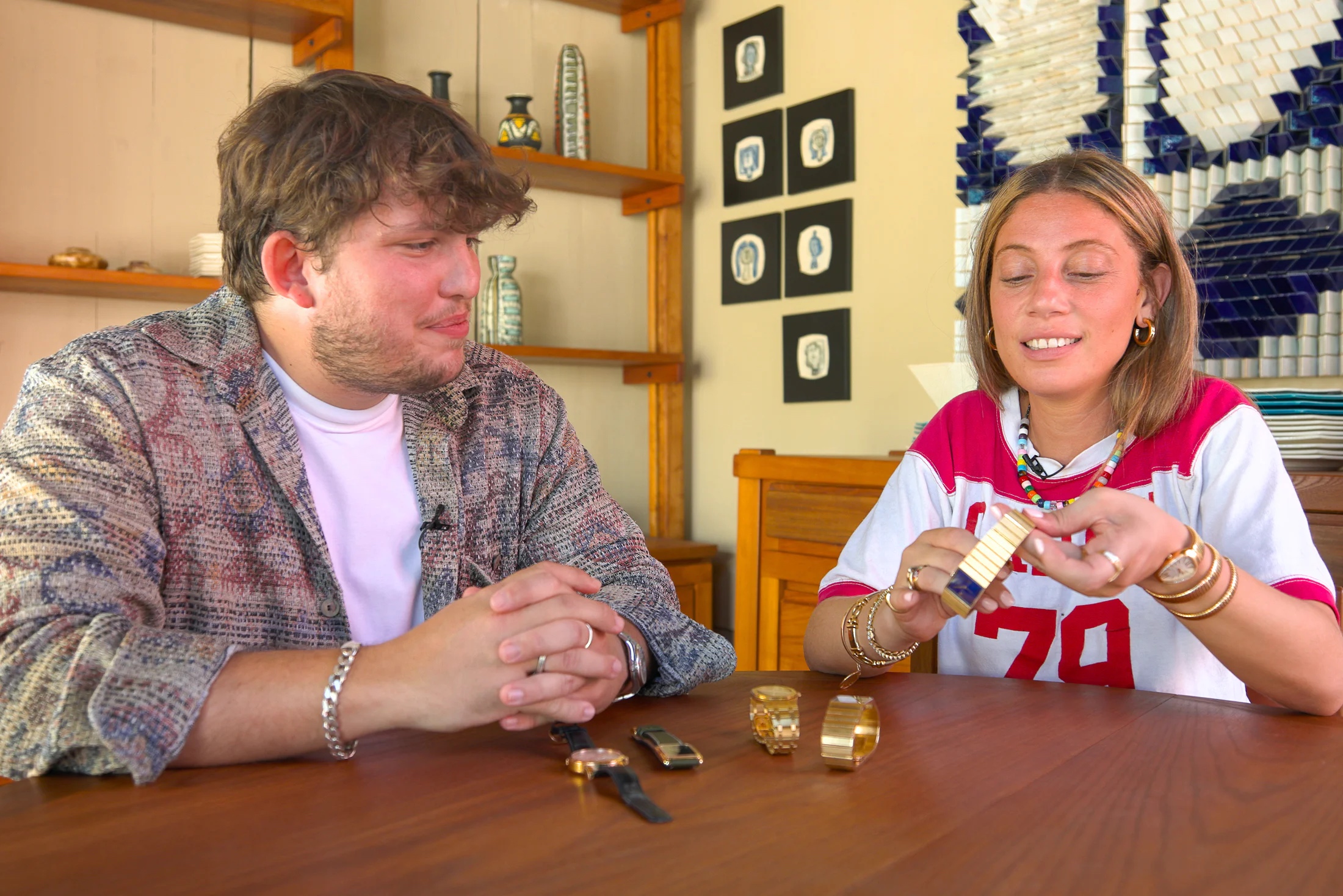 Malaika (right) holds a watch and discusses the collection of her friend Arthur (left)