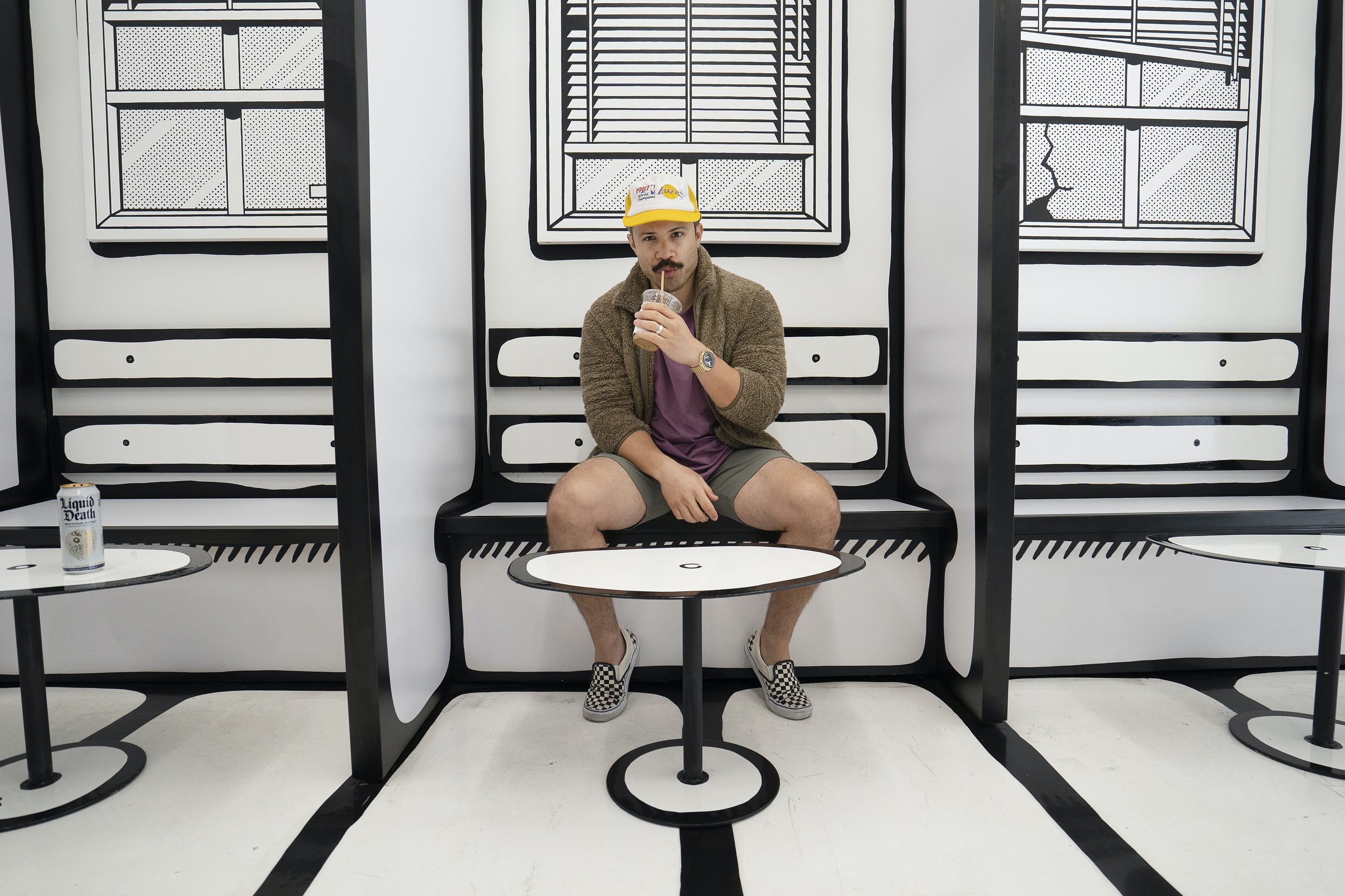 the author, wearing an Omega Moonshine Gold Speedmaster while sitting at a table and drinking a soda