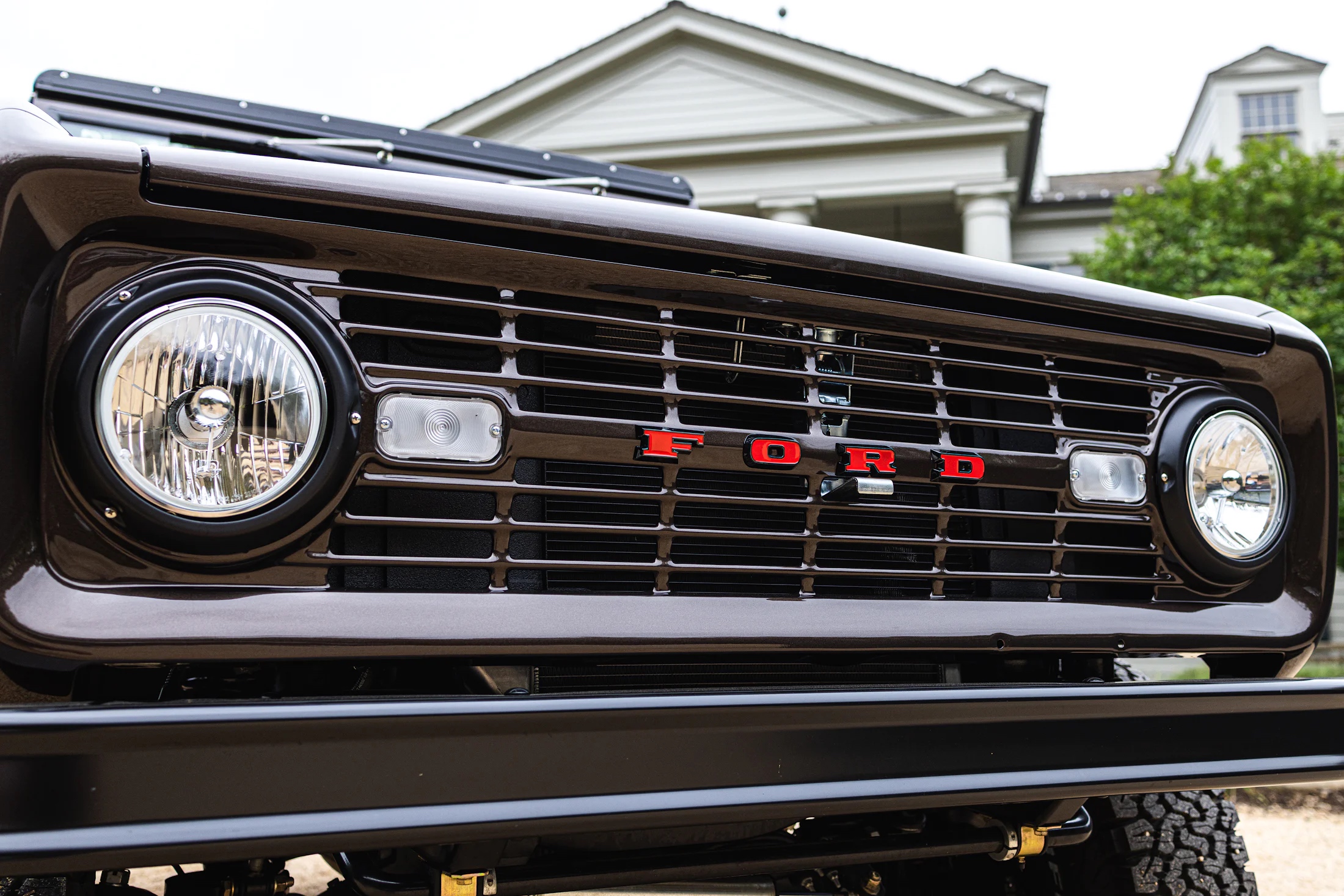 Close up of the headlights and front bumper of the Ford Bronco. The large red text says "FORD"