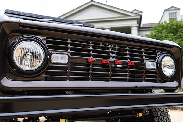 Close up of the headlights and front bumper of the Ford Bronco. The large red text says "FORD"