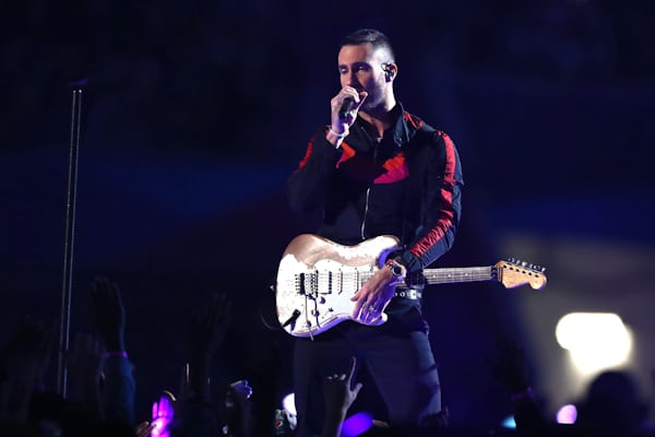 Adam Levine performing at the Super Bowl while wearing a rose gold rainbow rolex daytona