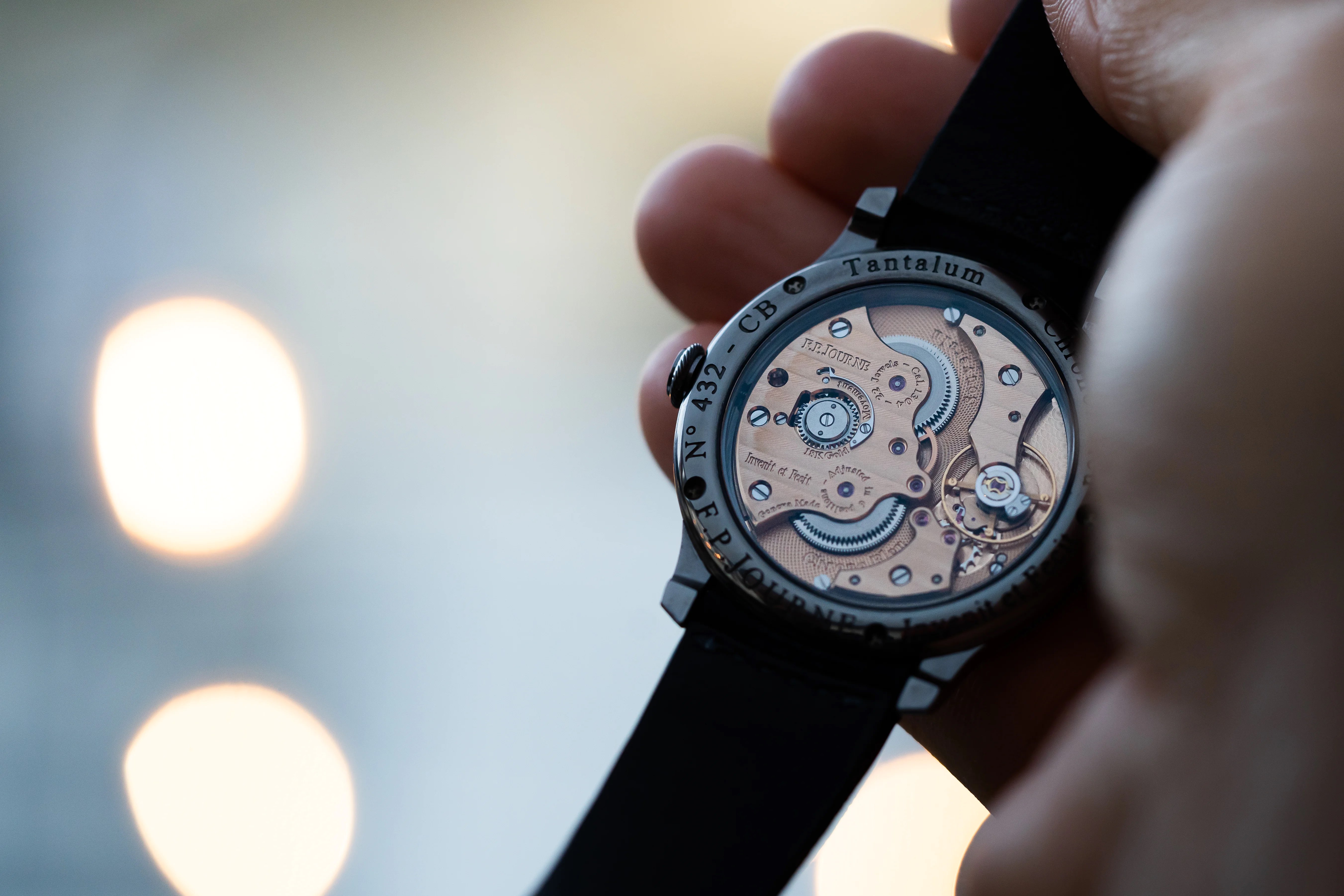 hand holding up watch showing of the case back