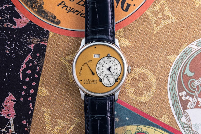 F.P. Journe watch with yellow dial on an ornate background