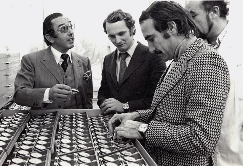 1971 photo of Jack Heuer, Niki Lauda, and Clay Regazzoni looking at watches