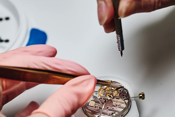 a person working on a watch movement 