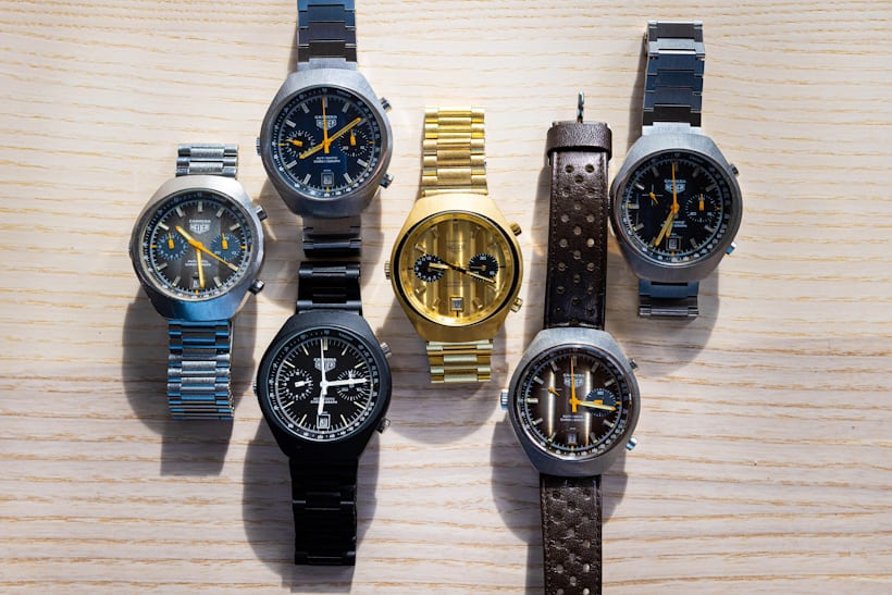 A group of carrera watches with barrel cases laid out on a wooden surface