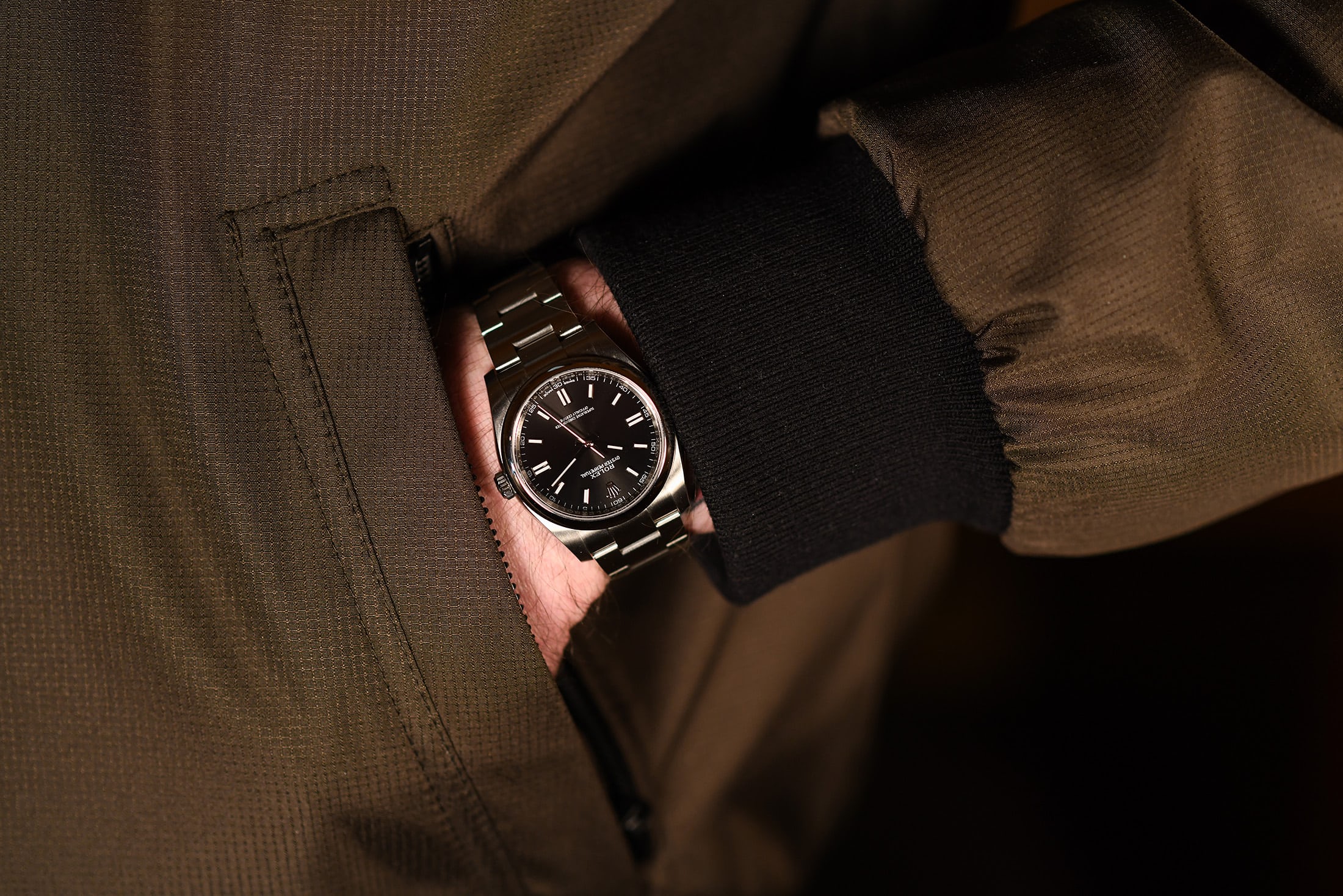 A hand in a pocket wearing a Rolex Oyster Perpetual 