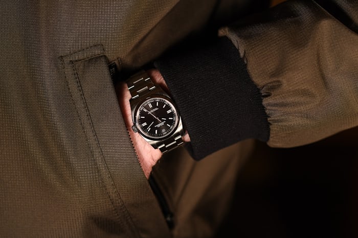 A hand in a pocket wearing a Rolex Oyster Perpetual 