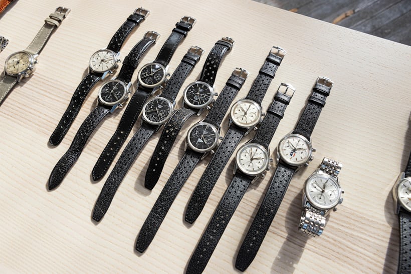 A group of carrera watches laid out on a wooden surface