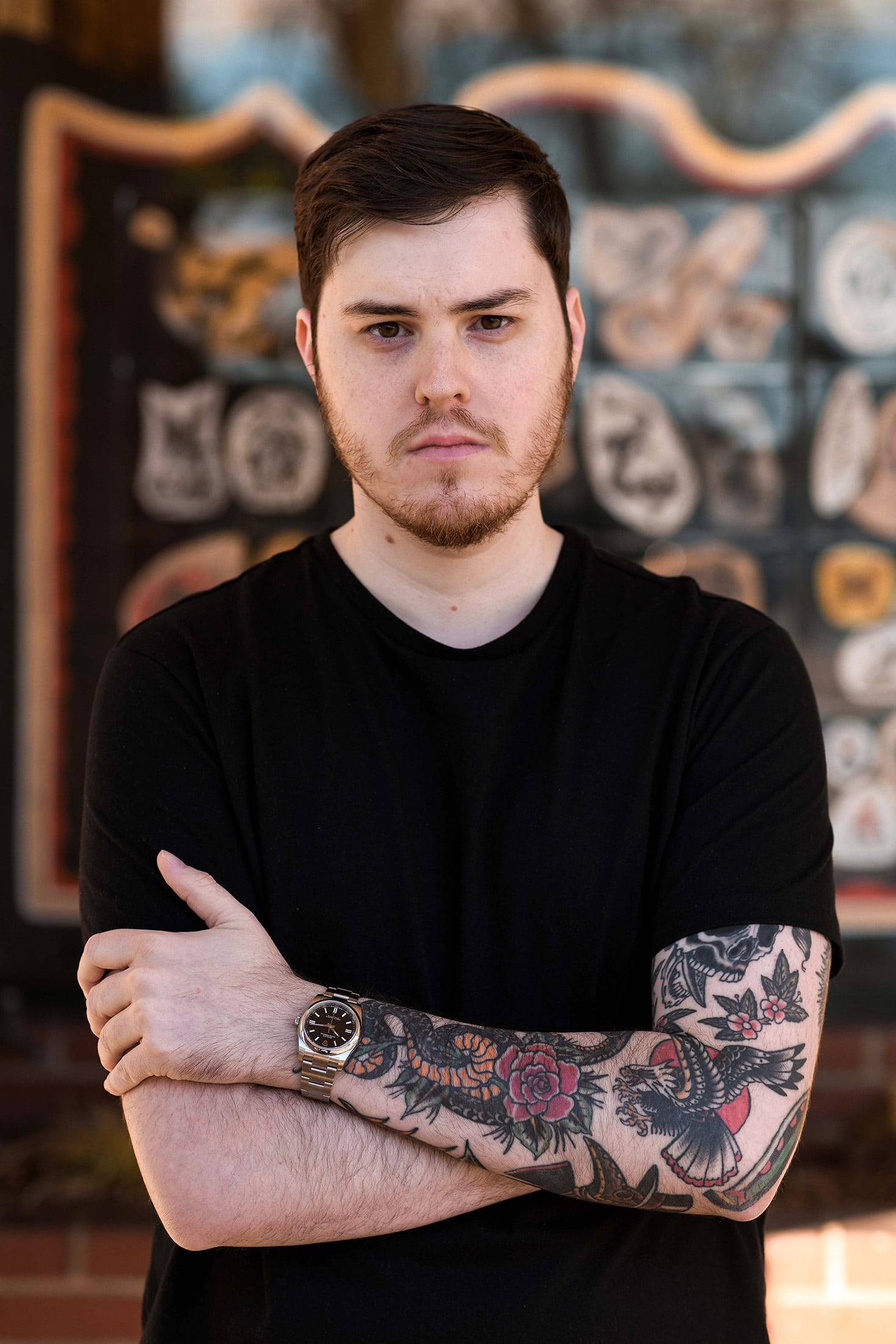 he author poses with his arms crossed, Rolex Oyster Perpetual on his wrist