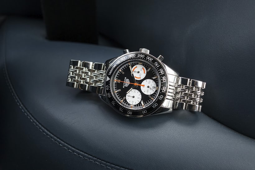 The TAG Heuer Autavia Calibre Heuer 02 For HODINKEE leaning on its side in the front seat of a car.